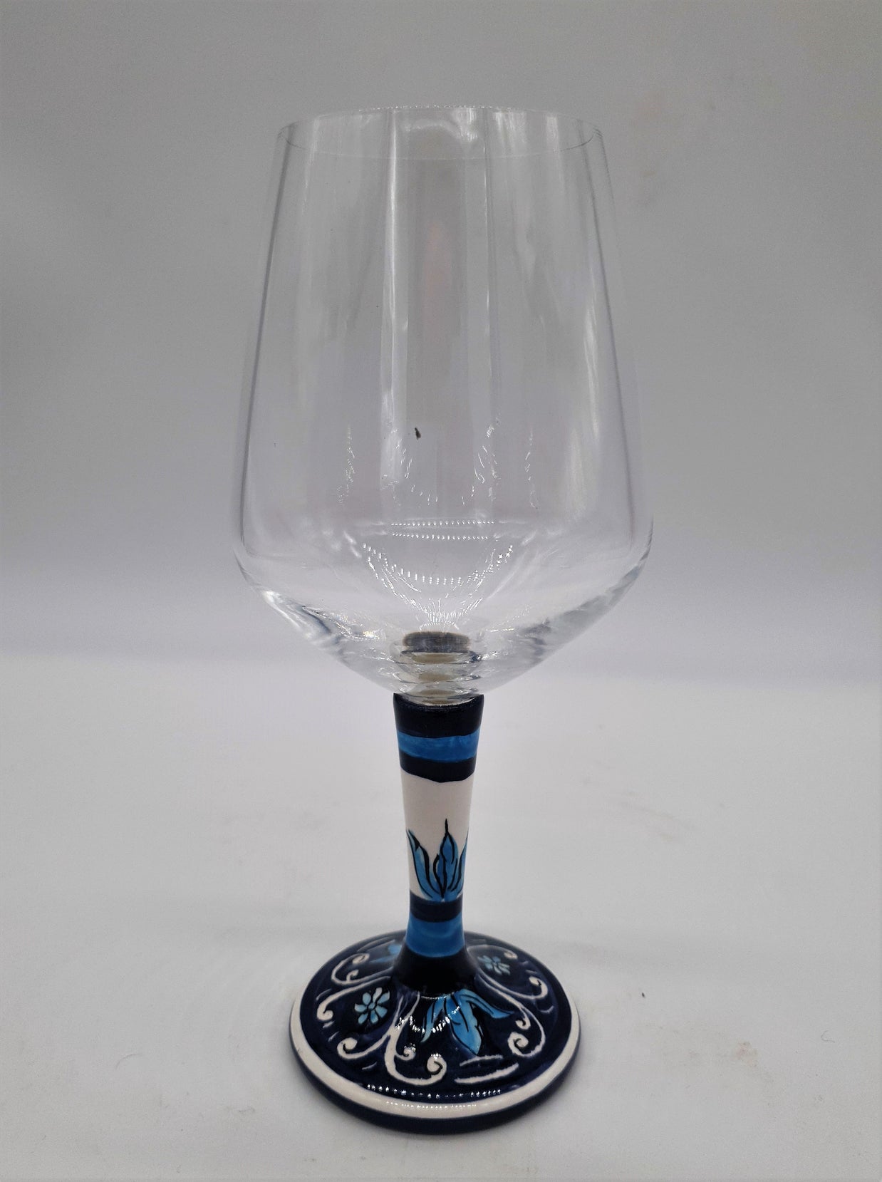 Glass for Wine Ceramic and White Graffiti Glass on a Blue Background